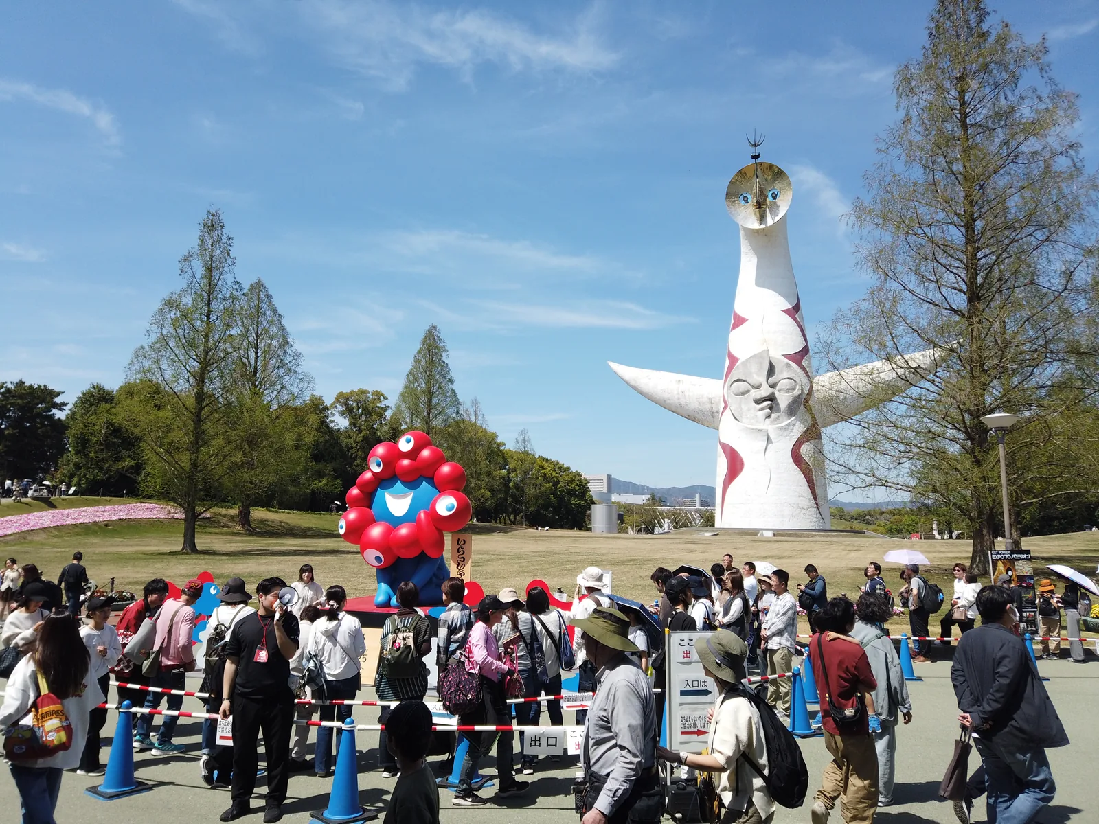 万博記念公園、太陽の塔とミャクミャク像が並び立つ広場と来場者