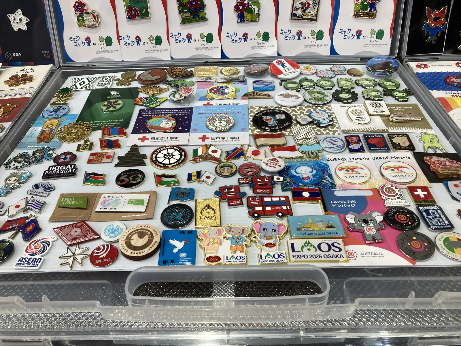 各国のピンバッジがずらりと並ぶ記念グッズの展示ケース