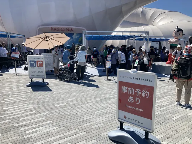 PASONA NATUREVERSE 前に並ぶ家族とアトムの像
