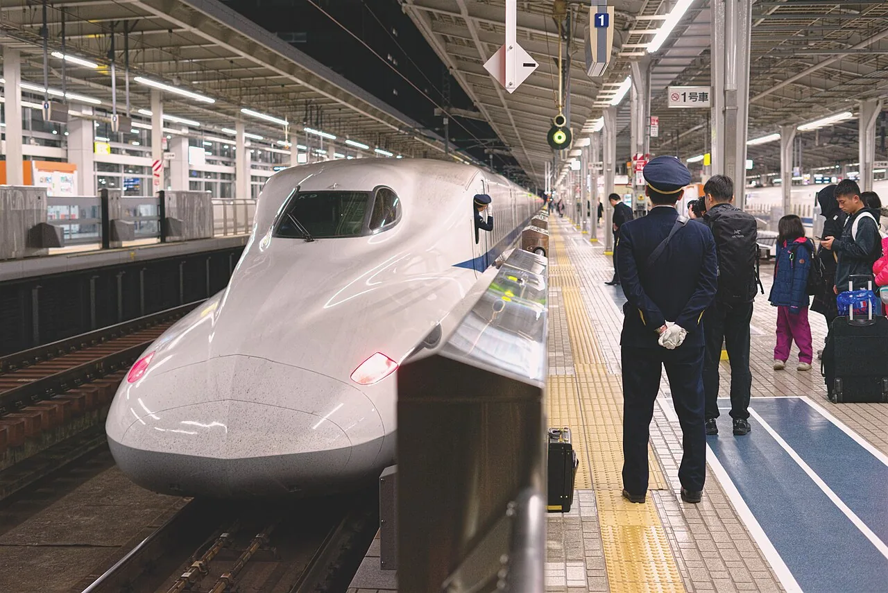 新大阪駅を発つ新幹線と車掌の敬礼