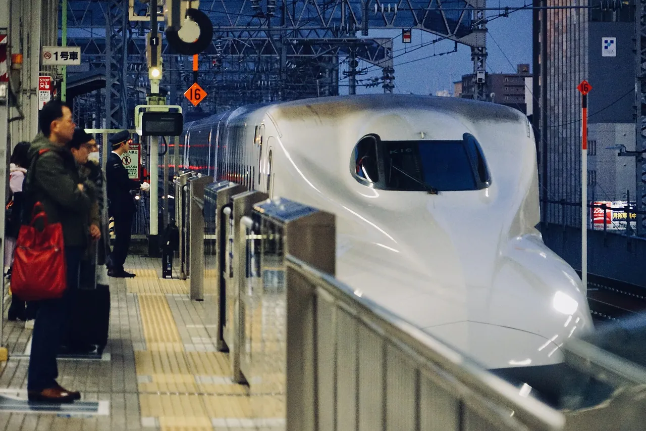 新大阪駅の新幹線ホームに停車するN700系と、乗車を待つ人びと