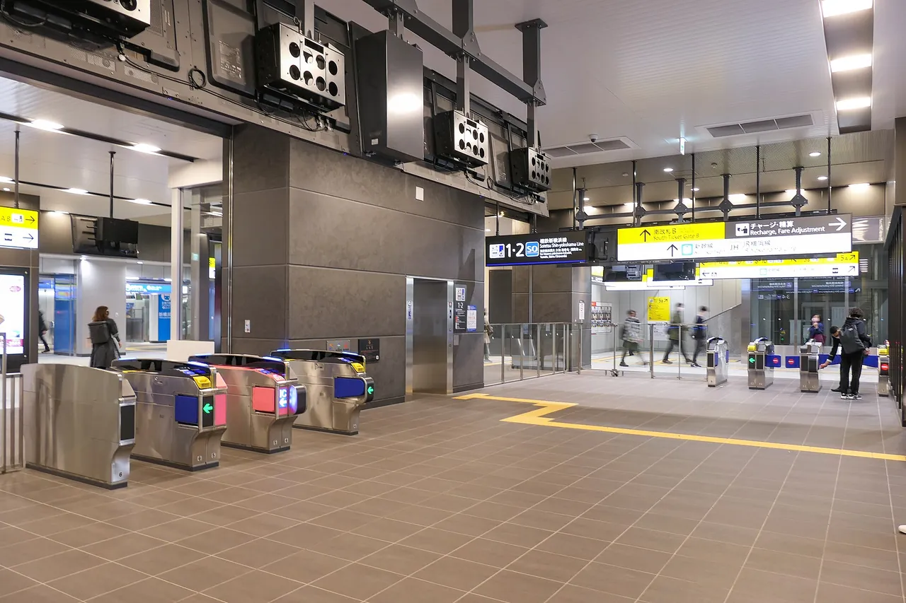 新横浜駅の改札口コンコース。案内サインと自動改札が並ぶ