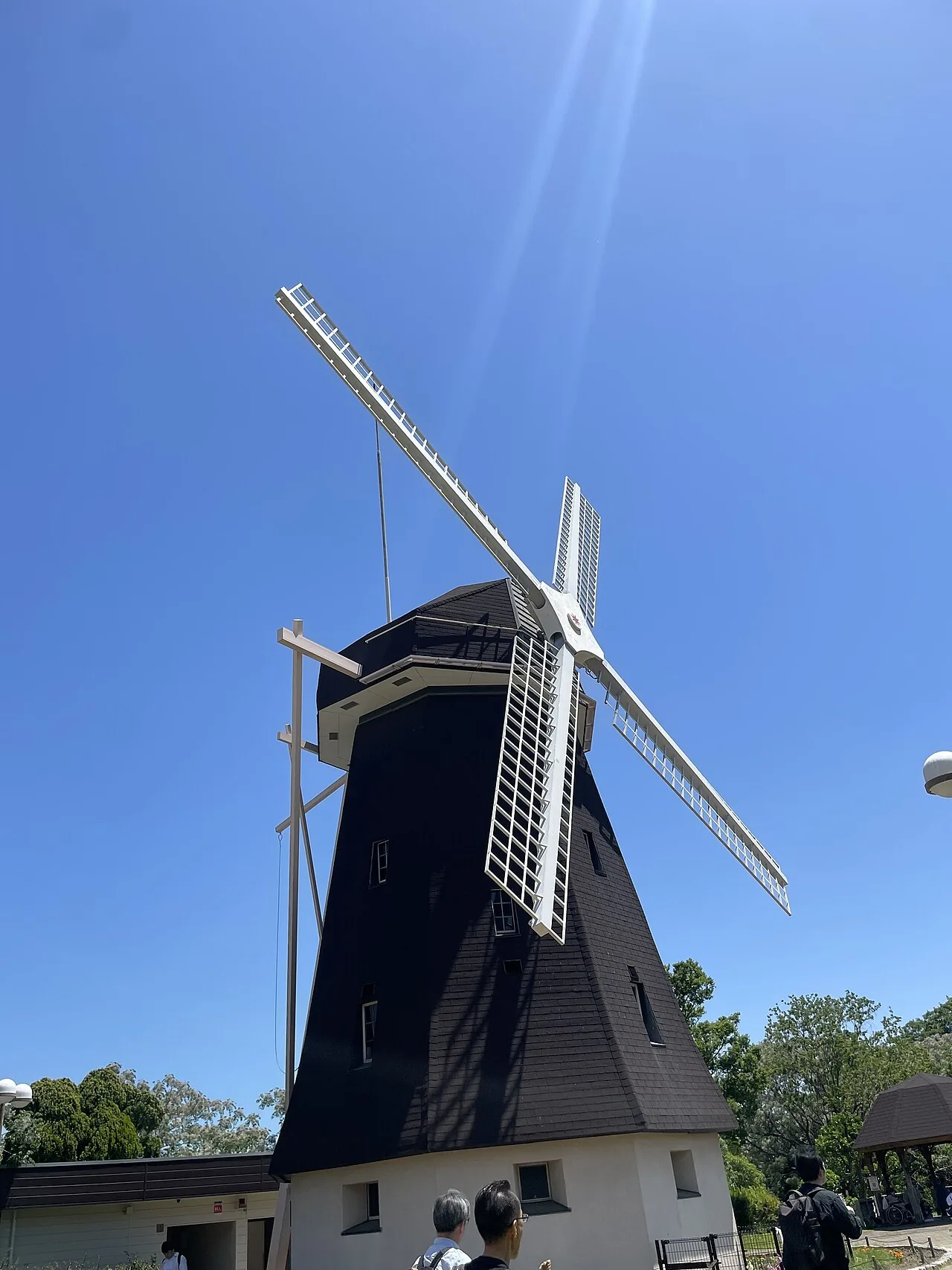 青空を背に羽根を広げる花博記念公園鶴見緑地のオランダ風風車
