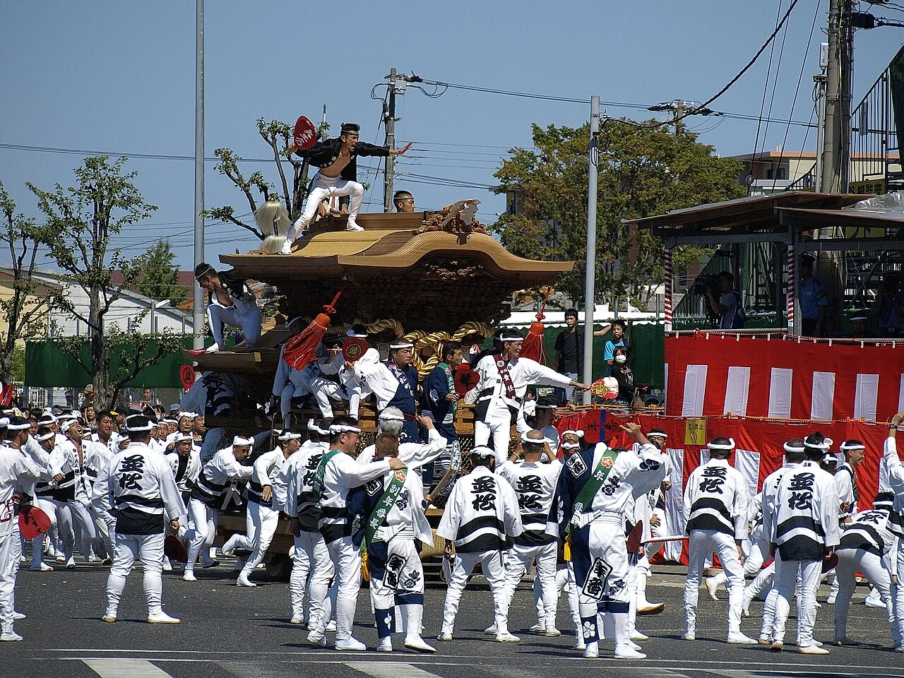 法被姿の曳き手たちが街角を駆け抜ける岸和田だんじり祭
