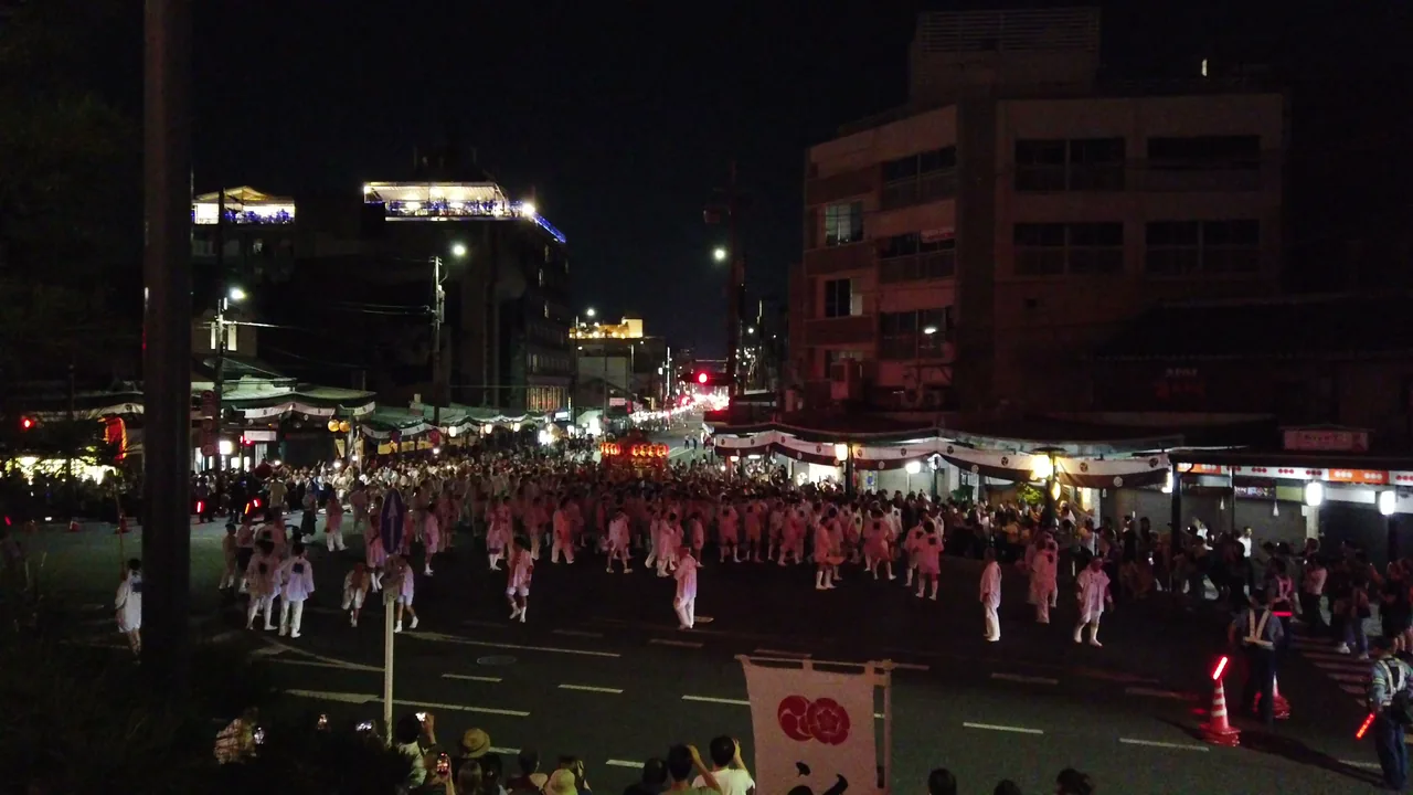 夜の四条通を埋めつくす、白装束の神輿の担ぎ手たちの群れ