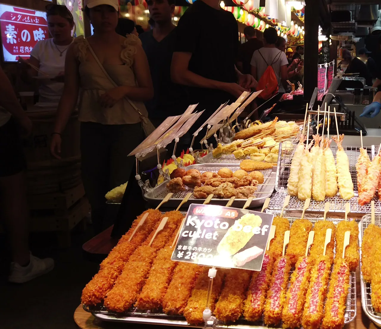 錦市場の店先に並ぶ揚げ物の串。神戸ビーフカツの値札に3,000円と書かれている