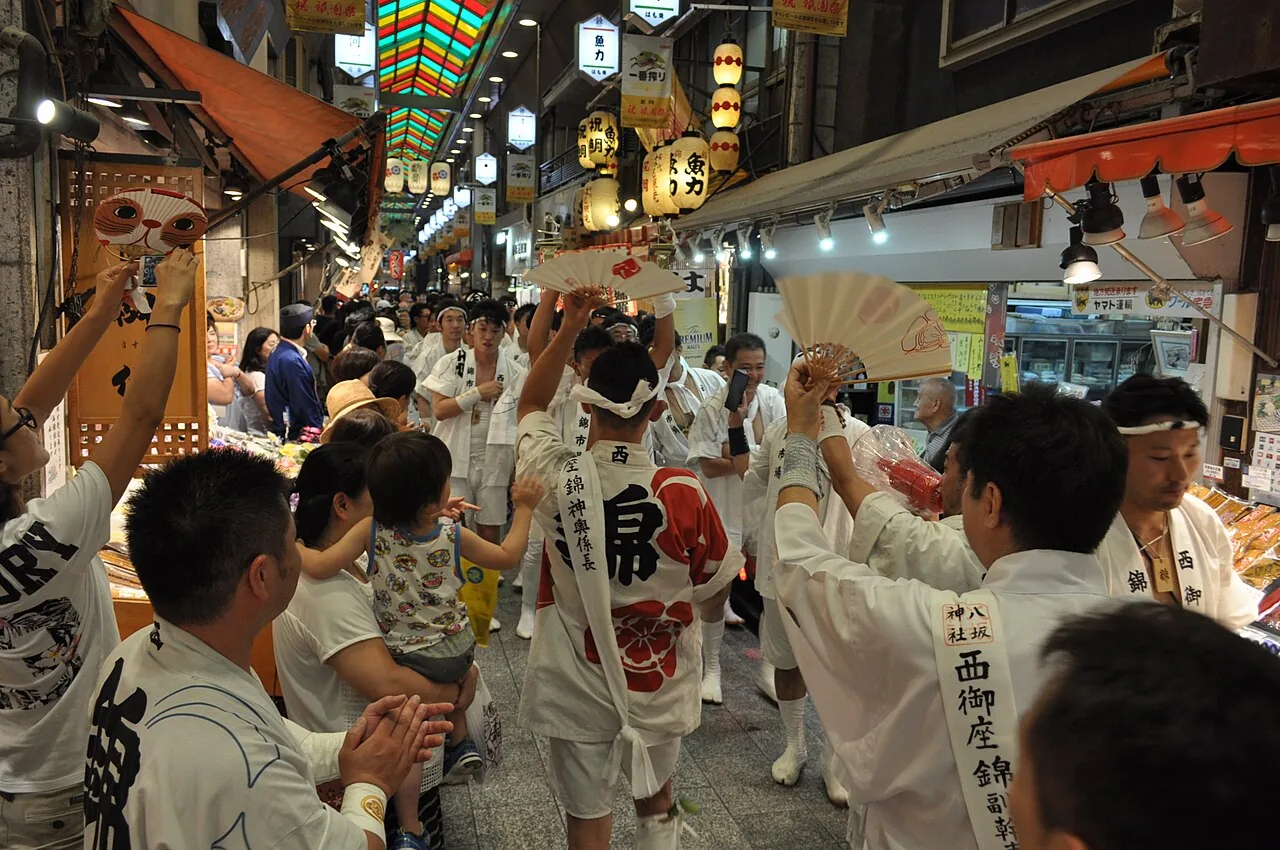 祇園祭の時期、神輿の担ぎ手たちが錦市場のアーケードを練り歩く