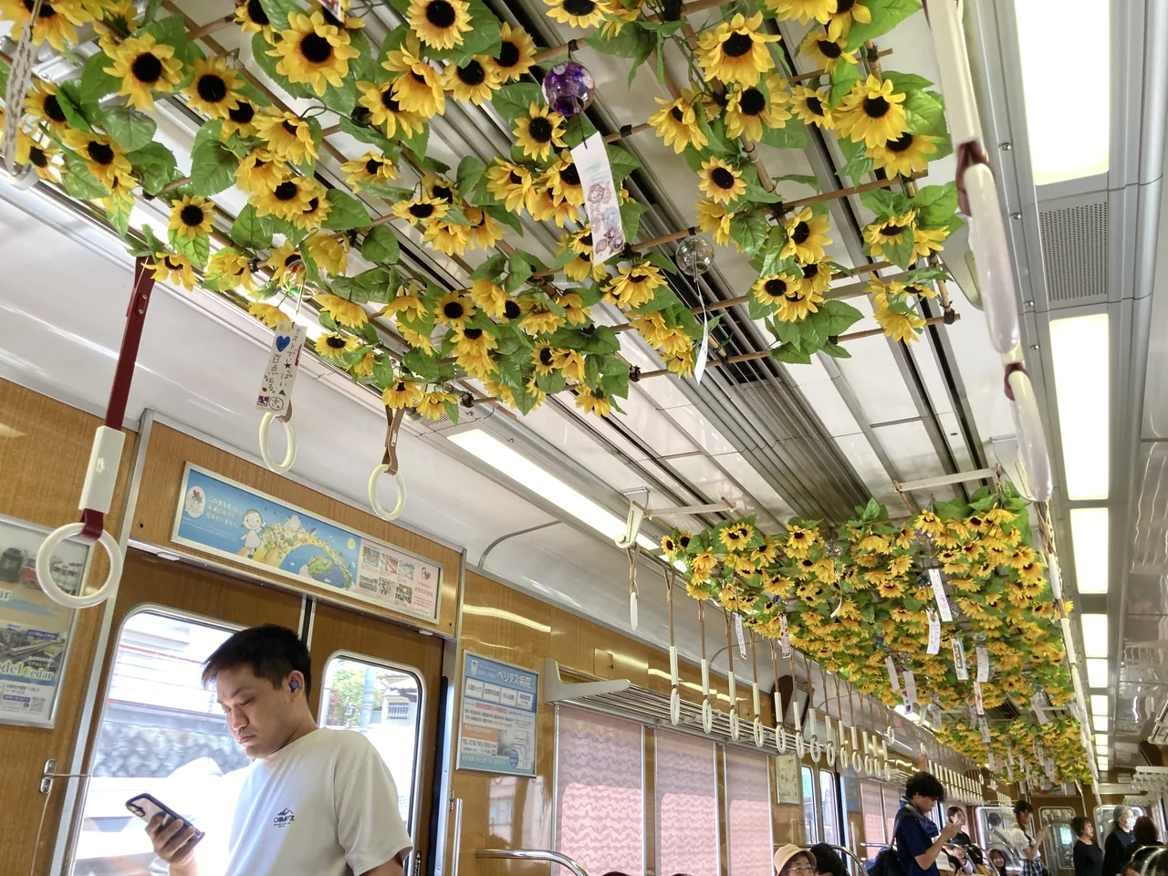 ひまわりの造花で埋めつくされた車内の天井と、座席にすわる乗客