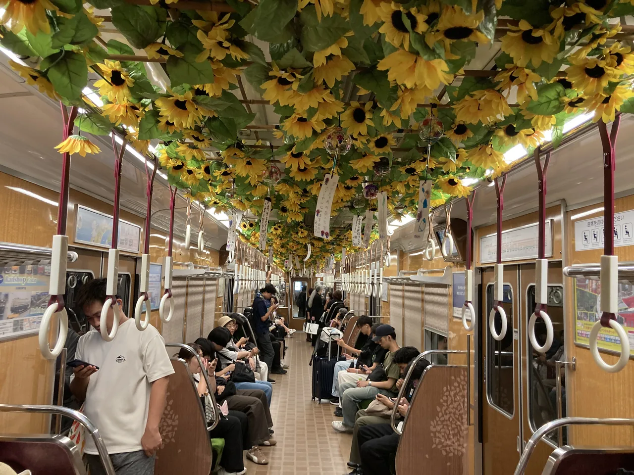 車内の天井いっぱいに飾られたひまわりの造花。ガラスの風鈴と短冊も下がっている