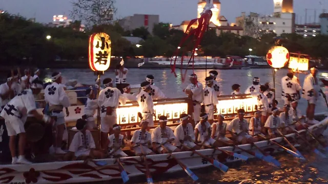 夕暮れの大川を進む天神祭の船渡御