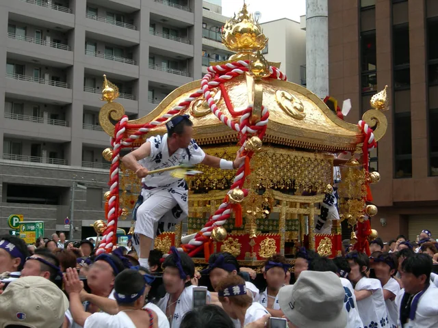 金色の玉神輿を担ぐ担ぎ手たち