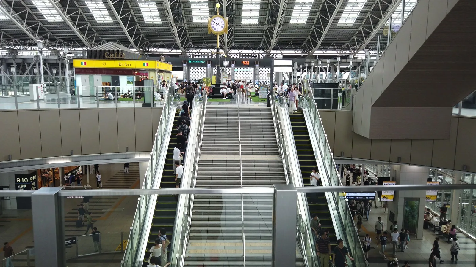 大阪駅の時空の広場。大屋根の下に金色の時計が下がり、エスカレーターが上下に伸びる