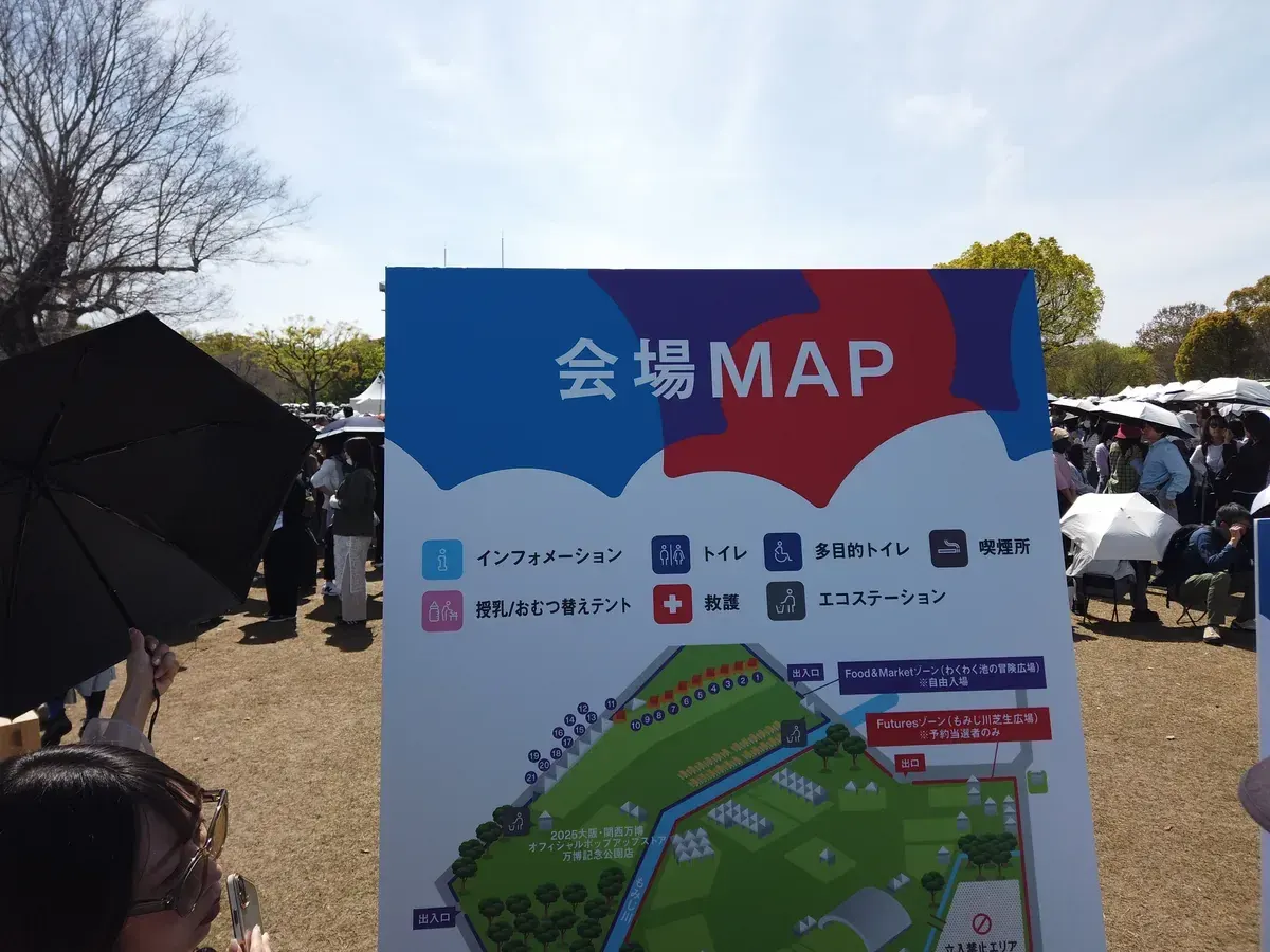 1周年メモリアルイベントの会場MAP看板を眺める来場者