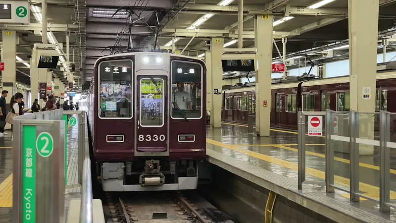 阪急大阪梅田駅のホームに停まるマルーン色の電車