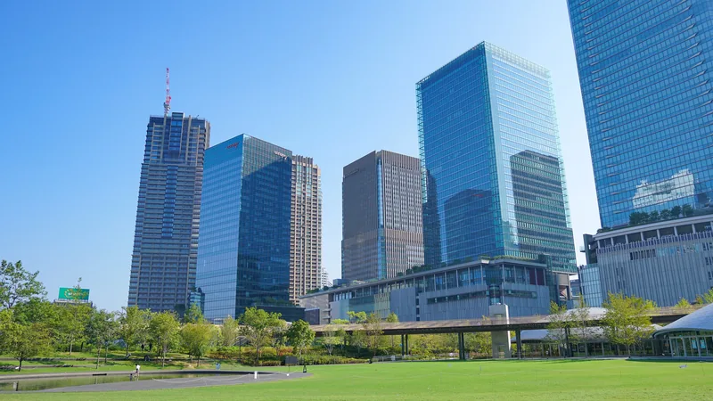 芝生広場とグランフロント大阪、北館。奥で高層棟の建設が進む（2025年8月）