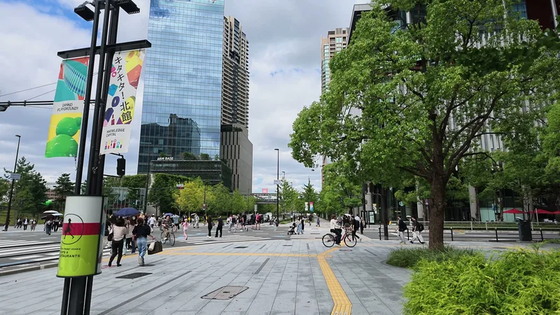 グラングリーン大阪のバナーが掛かる並木の歩道