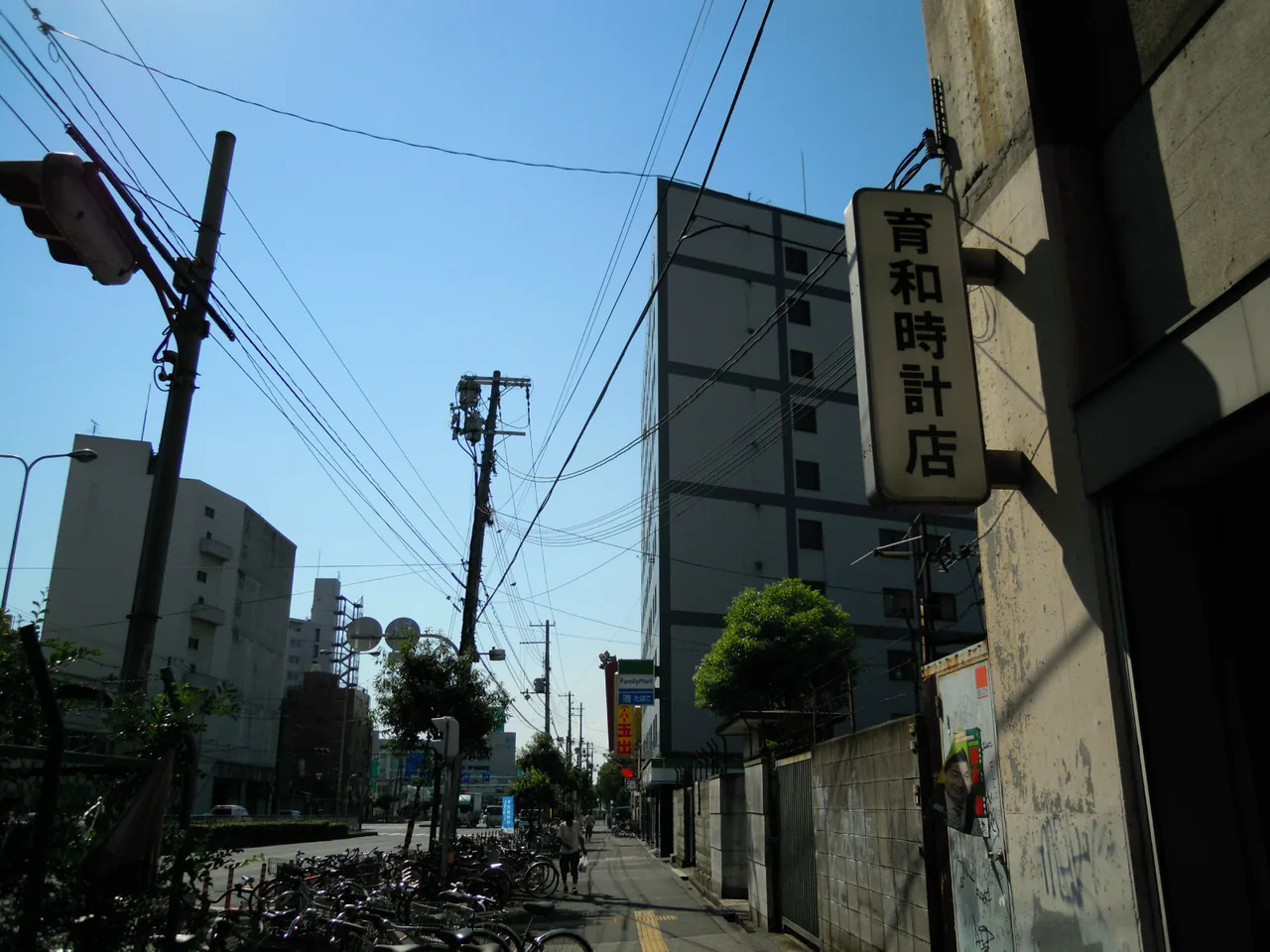 西成区萩之茶屋の路地。時計店の看板と低層の建物が並ぶ生活風景