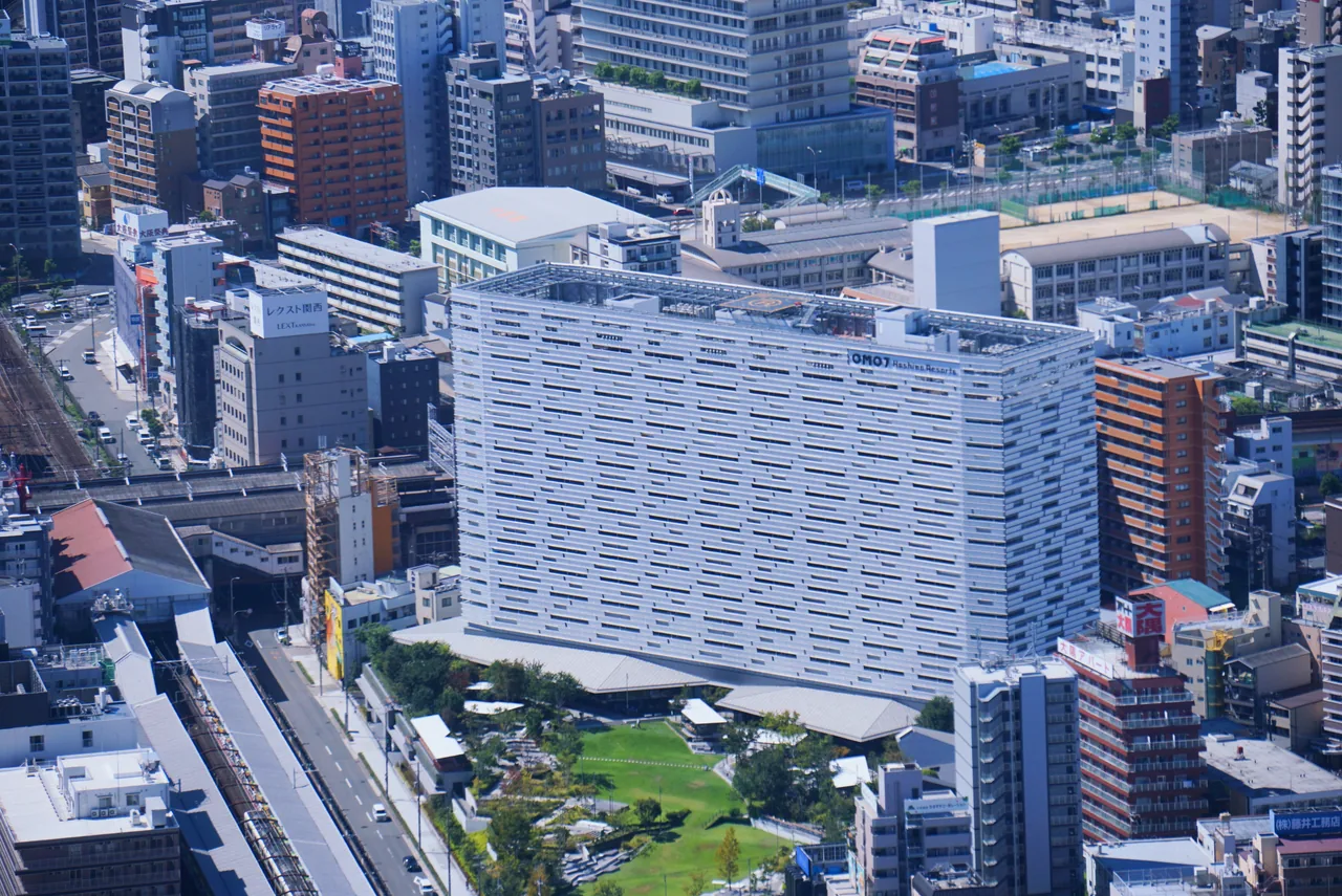 あべのハルカスから見た新今宮駅周辺。大きなホテルの建物と芝生の庭、周囲の街並み
