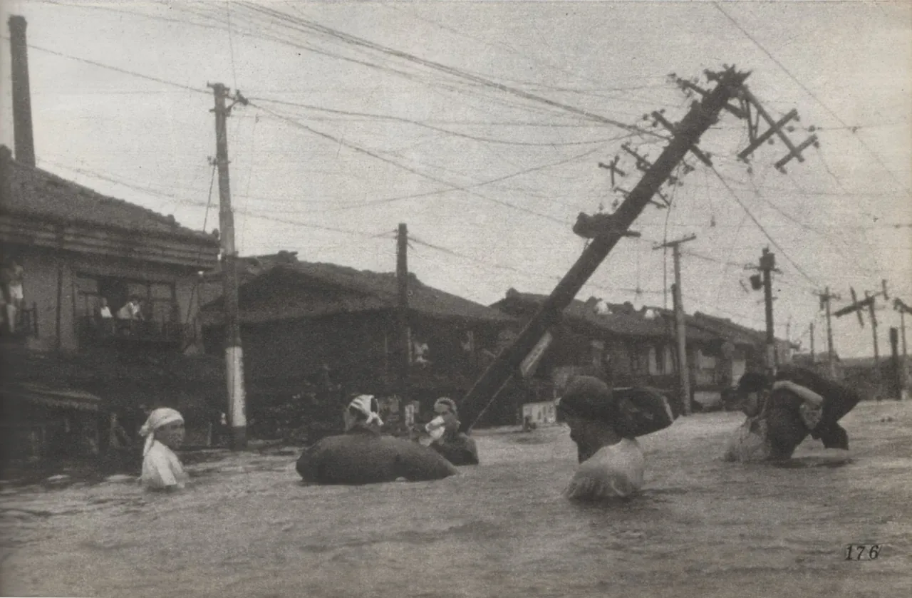 1950年のジェーン台風で浸水した大阪市港区市岡付近。冠水した街路を人々が歩く白黒写真